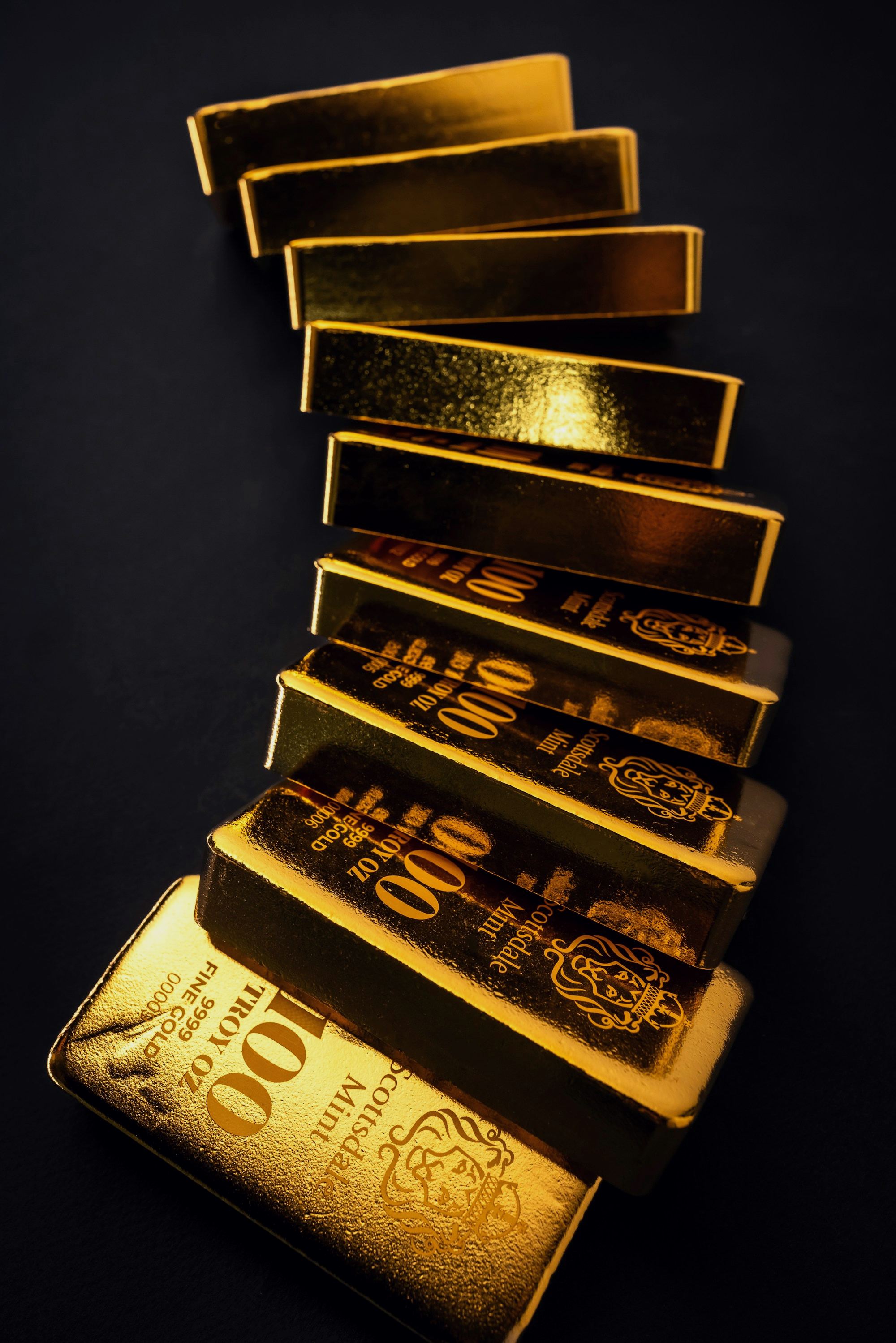 A row of gold bars on a dark surface